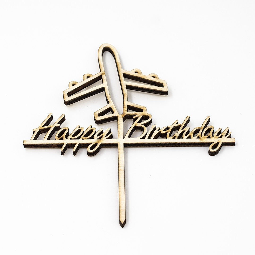 Wooderland laser-cut wooden cake topper featuring an airplane and Happy Birthday text in a playful script font.