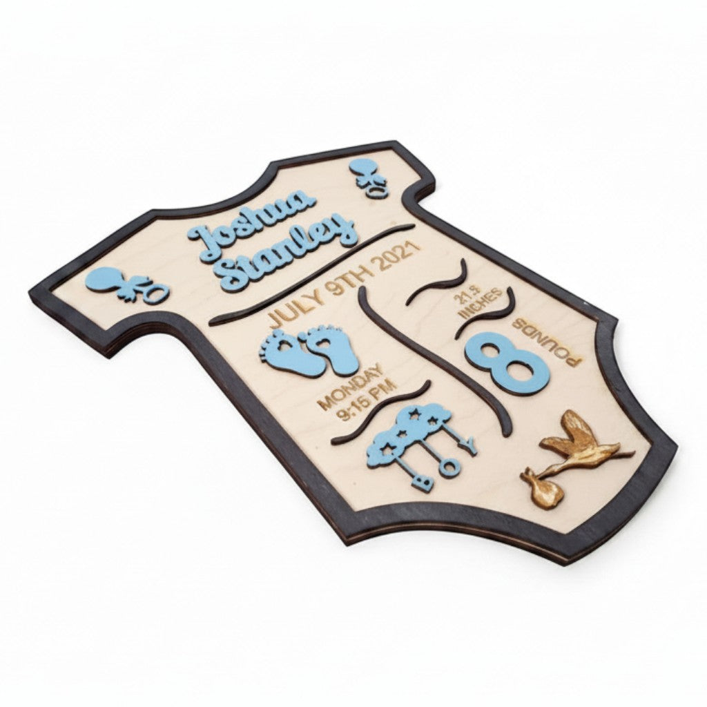 Wooderland personalized baby boy birth announcement sign in a onesie shape with blue accents and engraved details.