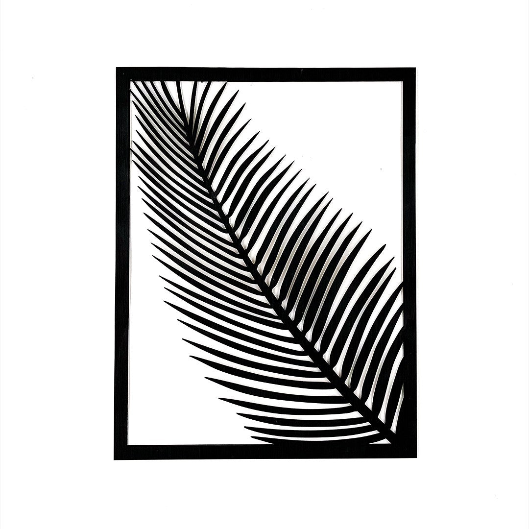 Wooderland wooden wall decor featuring a minimalist black carved palm leaf design in a rectangular frame.