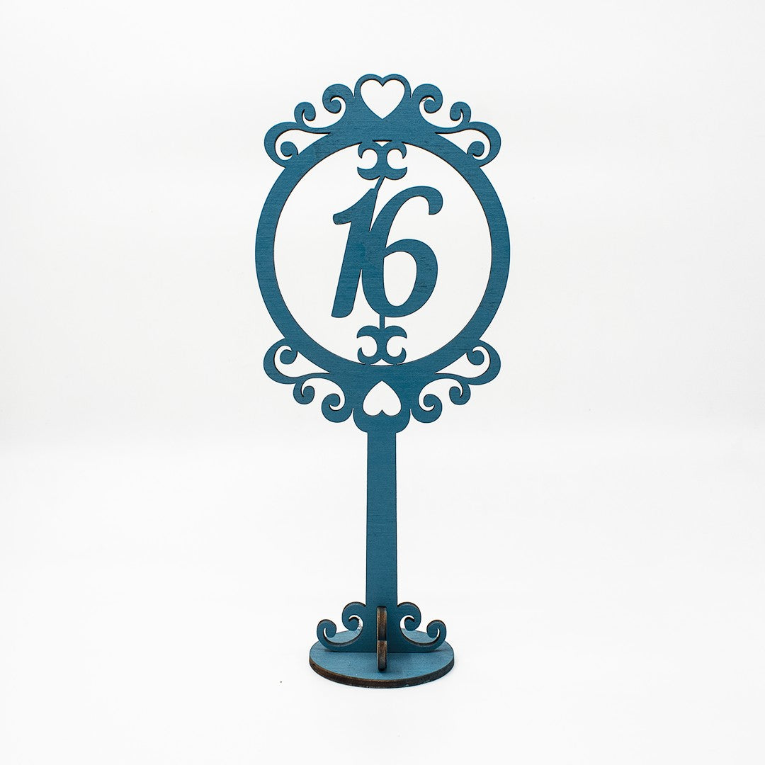 Wooderland freestanding blue wooden table number 16 with an ornate heart-shaped decorative frame for weddings