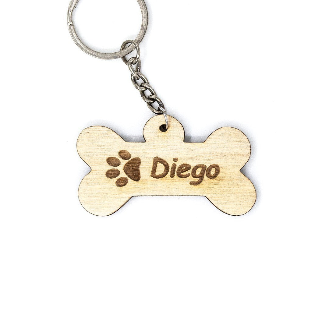 Wooderland bone-shaped wooden dog keyring with engraved paw print and the name Diego on a white background