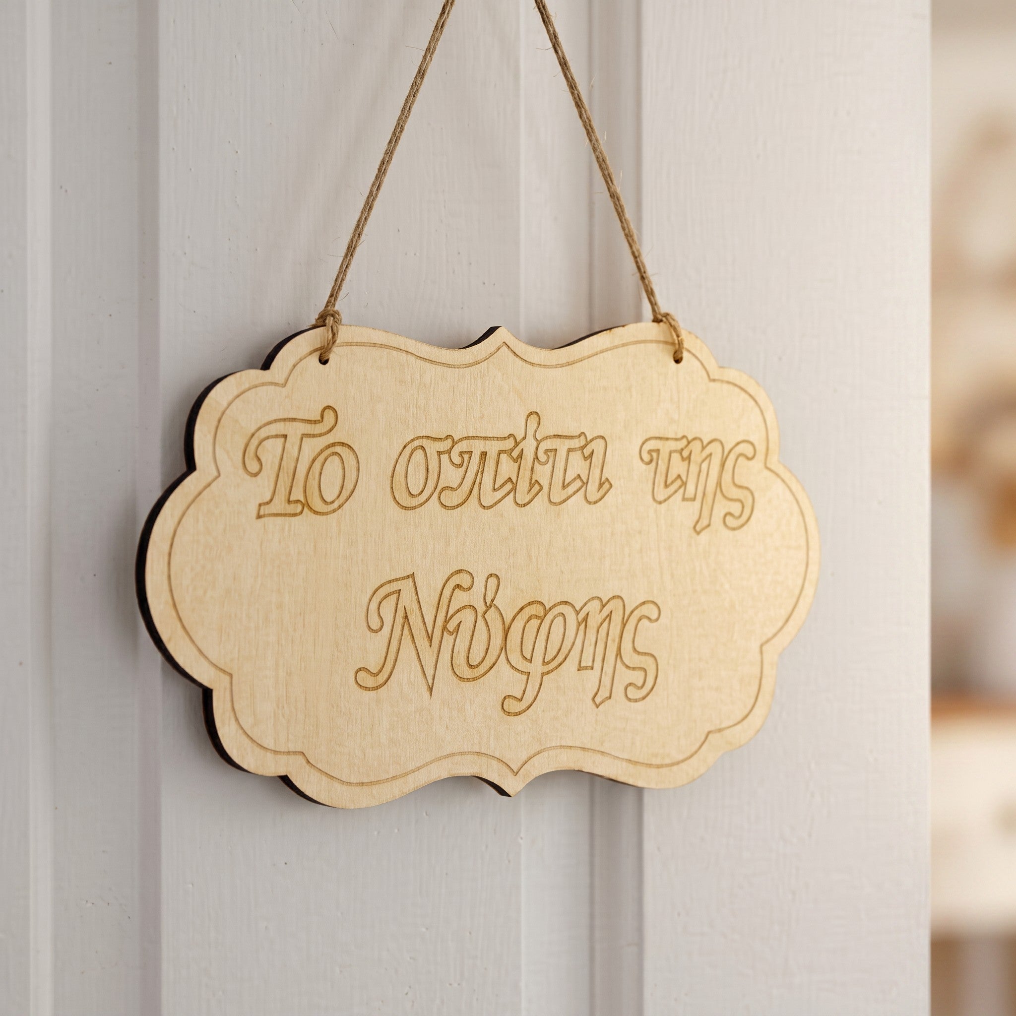 Wooderland laser-cut wooden sign for the bride's house with rustic twine hanging on a white door.