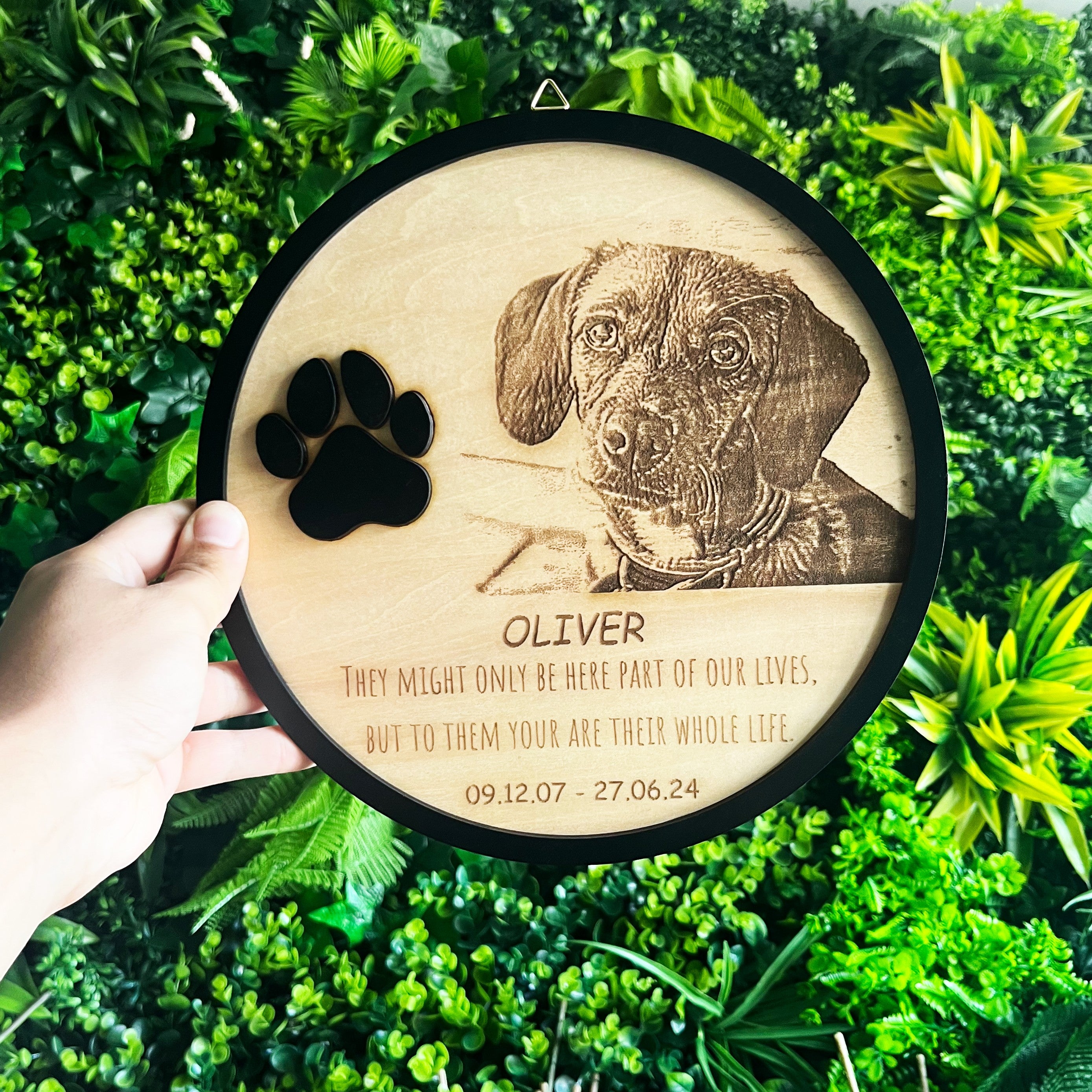 Wooderland circular wooden pet memorial plaque with custom engraved dog photo, name, dates, and black paw print accent.