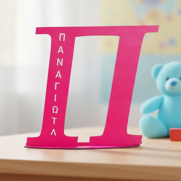 Wooderland custom pink wooden letter sign with name on a base, displayed on a child's playroom table.