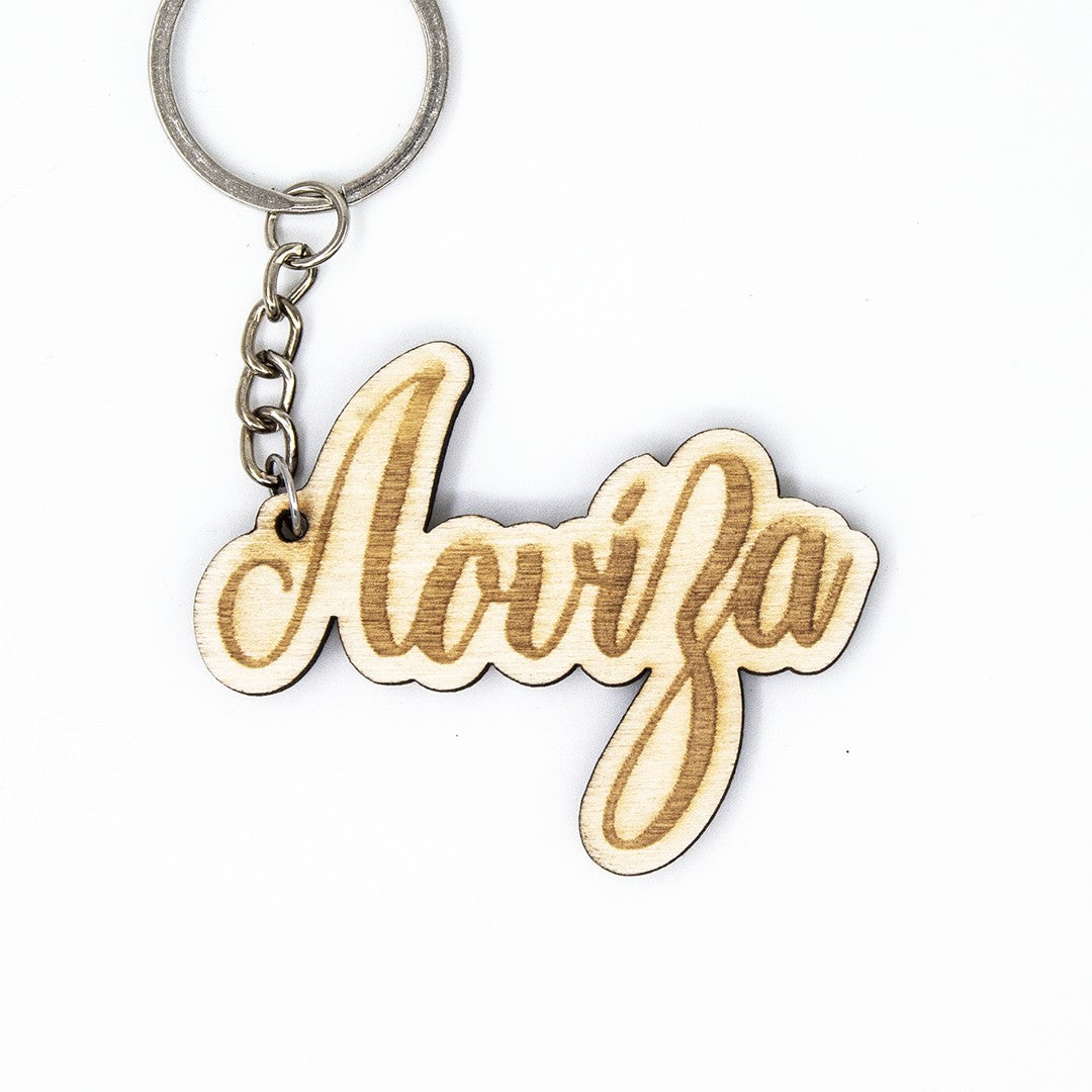 Wooderland custom laser-engraved wooden name keyring with cursive script font on a silver metal keychain ring