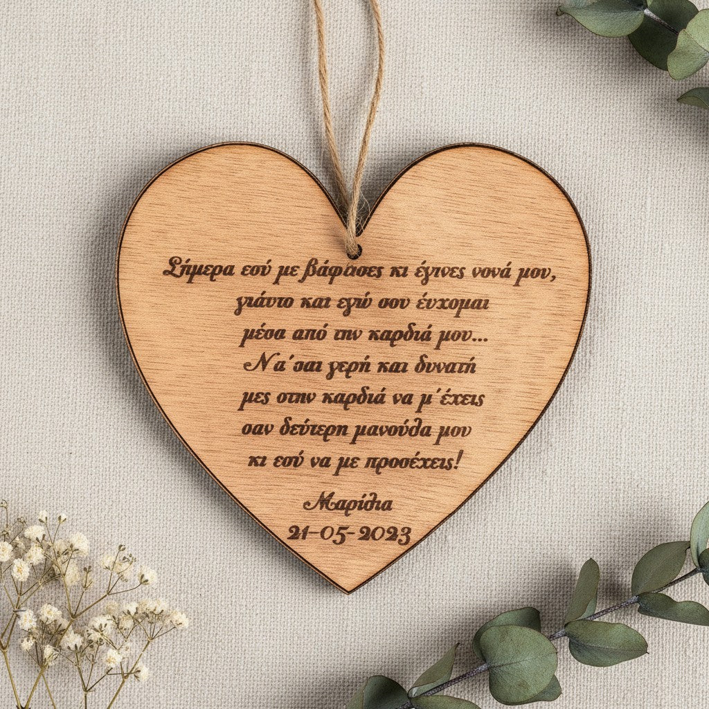 Wooderland heart-shaped wooden ornament engraved with a Greek christening message, names, and date on a linen background