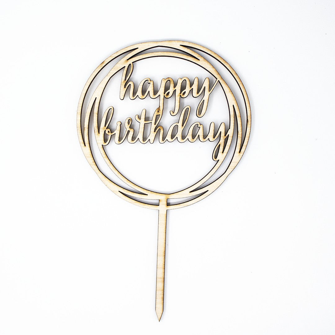 Wooderland laser-cut wooden Happy Birthday cake topper in a circular frame with elegant script font.