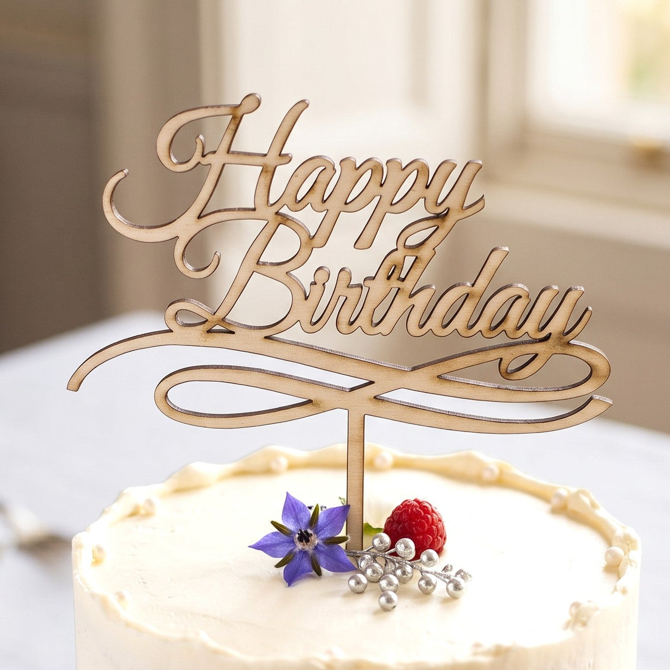 Wooderland laser-cut wooden Happy Birthday cake topper with elegant cursive font on a white frosted cake