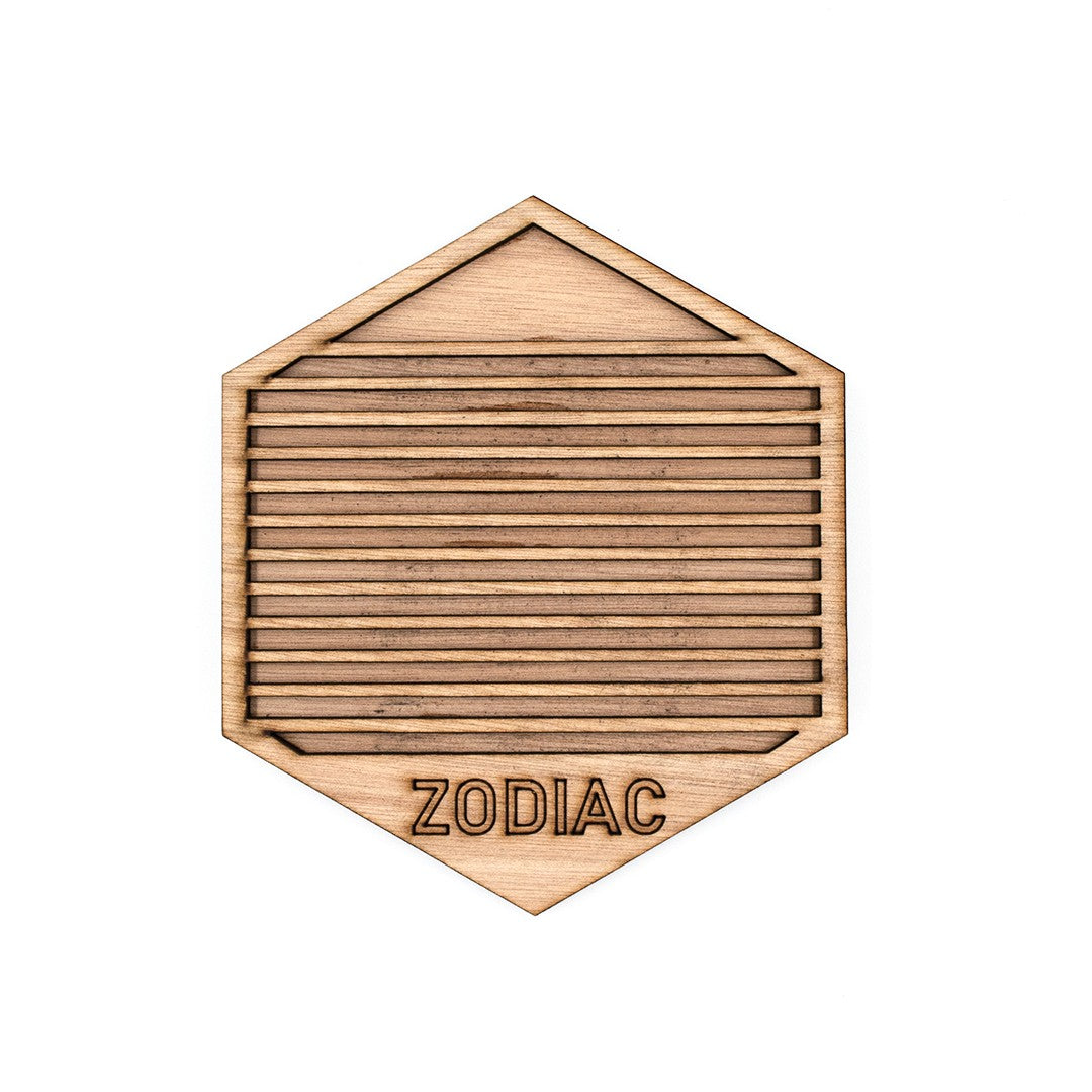 Wooderland hexagonal wooden coaster made from ocume wood with horizontal slats and engraved ZODIAC text.