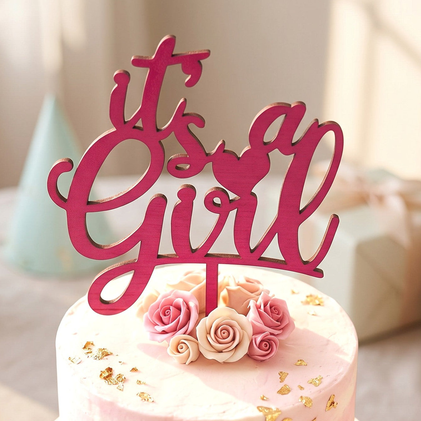 Wooderland It's a Girl wooden cake topper in dark pink, displayed on a tiered baby shower cake with floral accents.