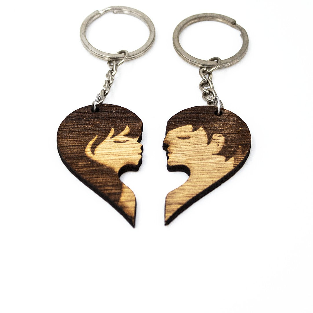 Wooderland matching heart-shaped wooden keyrings featuring laser-engraved silhouettes of a couple kissing.