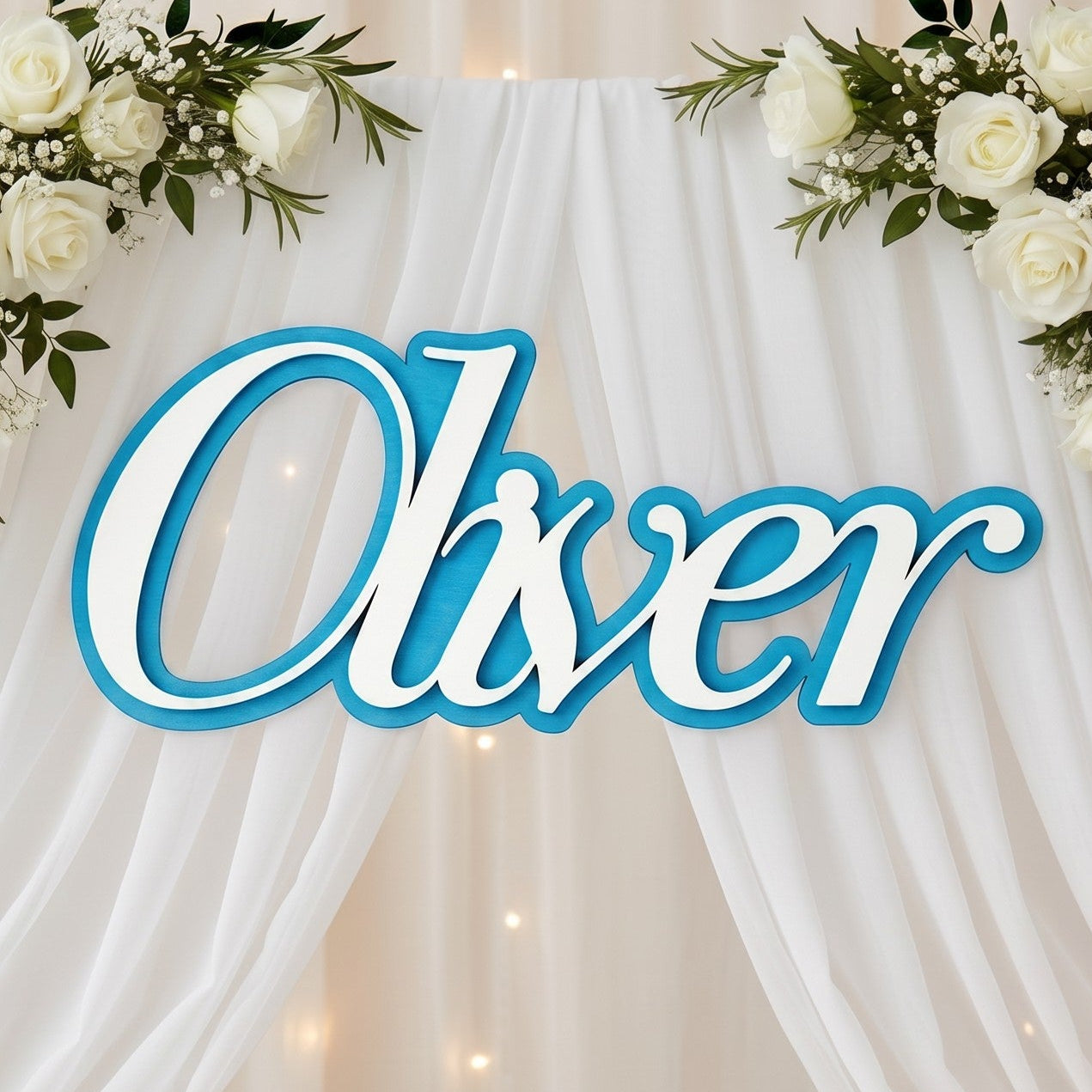 Wooderland custom layered wooden name sign in blue and white displayed on a christening backdrop with white roses.