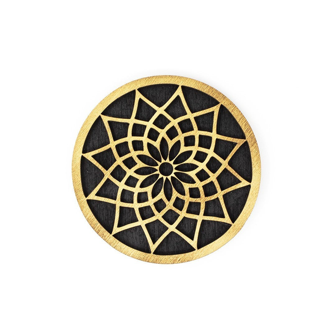 Wooderland round plywood coaster featuring an intricate laser-cut gold mandala pattern on a black background.
