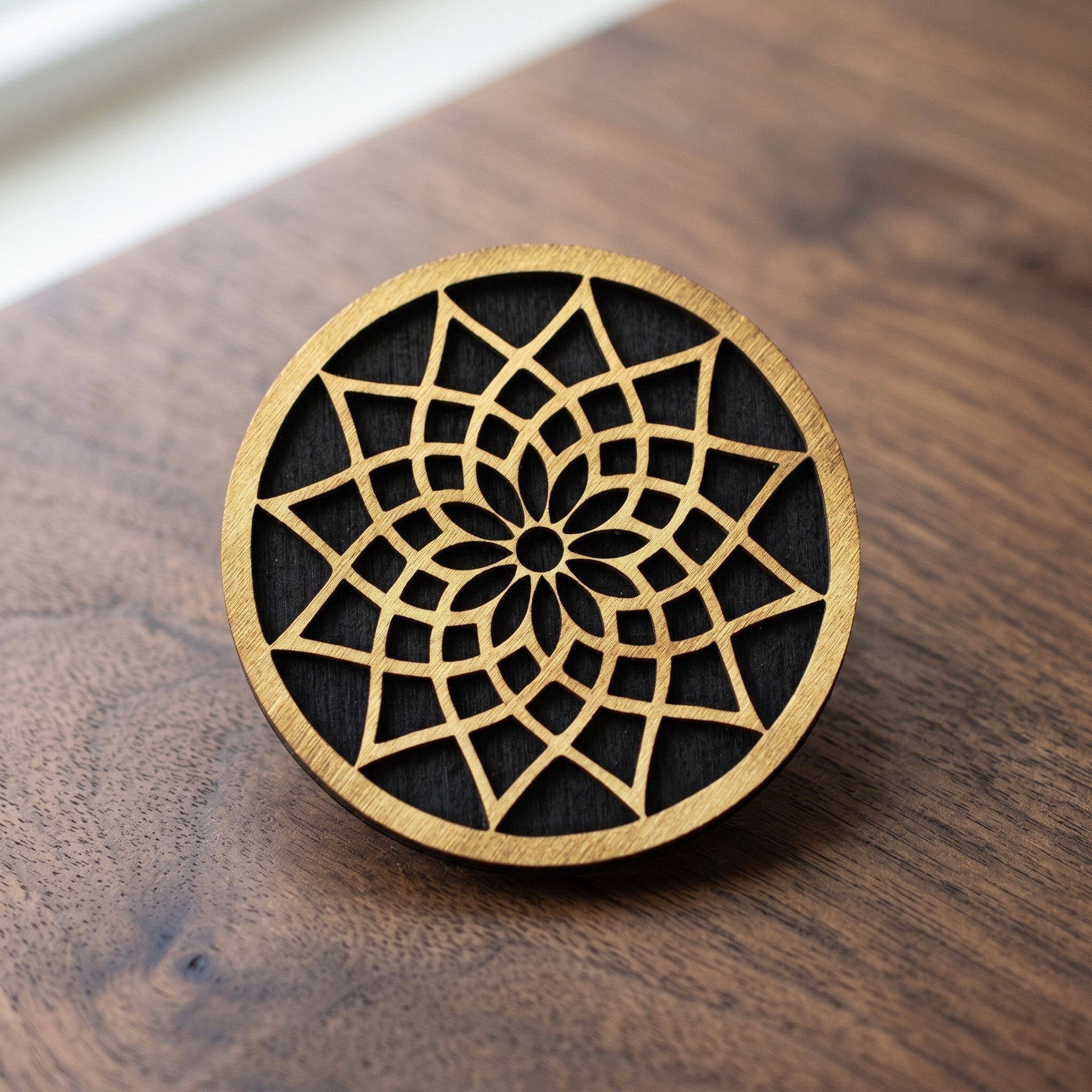 Wooderland round plywood coaster featuring a laser-cut gold mandala pattern on a black background.