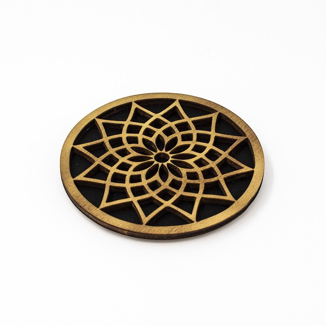 Wooderland round plywood coaster featuring an intricate laser-cut mandala pattern in natural wood and black finish.