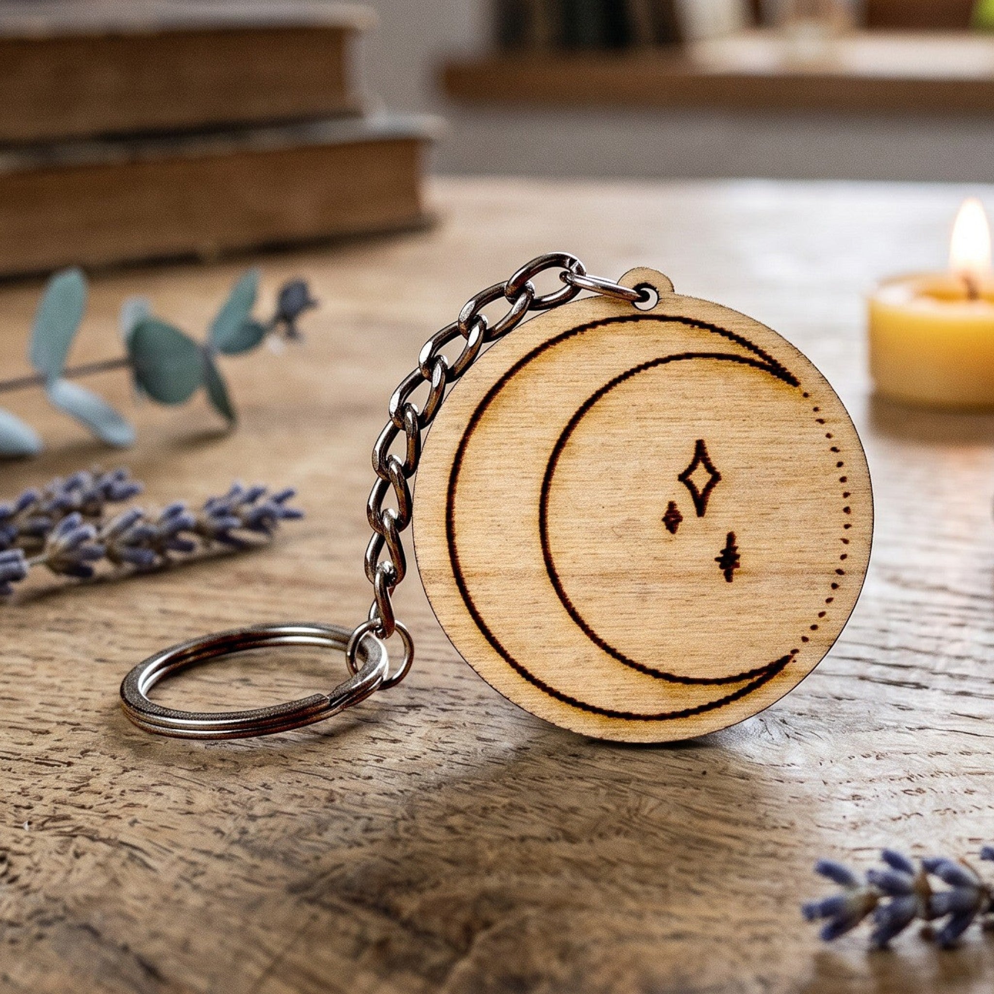 Wooderland moon engraved wooden keyring with metal chain on a rustic wooden table with a candle and crystal