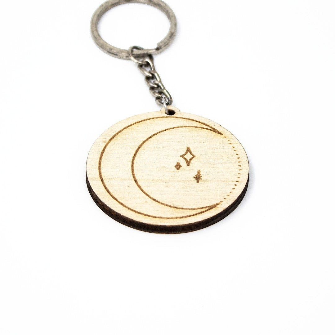 Wooderland round wooden keyring featuring a laser-engraved crescent moon and star design on a metal keychain ring.