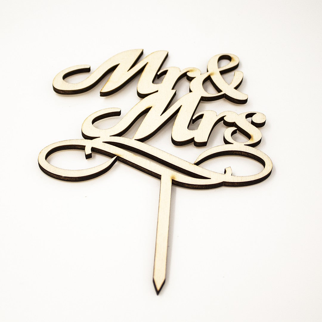 Wooderland Mr & Mrs wooden wedding cake topper with elegant laser-cut script lettering on a white background.
