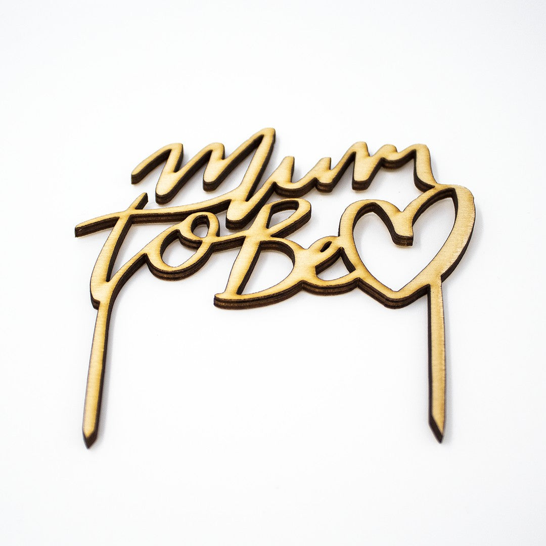 Wooderland Mum to Be wooden cake topper with laser-cut script and heart detail for a baby shower celebration.