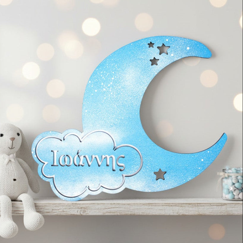 Wooderland personalized blue wooden moon wall decor with star cutouts and name display on a nursery shelf.