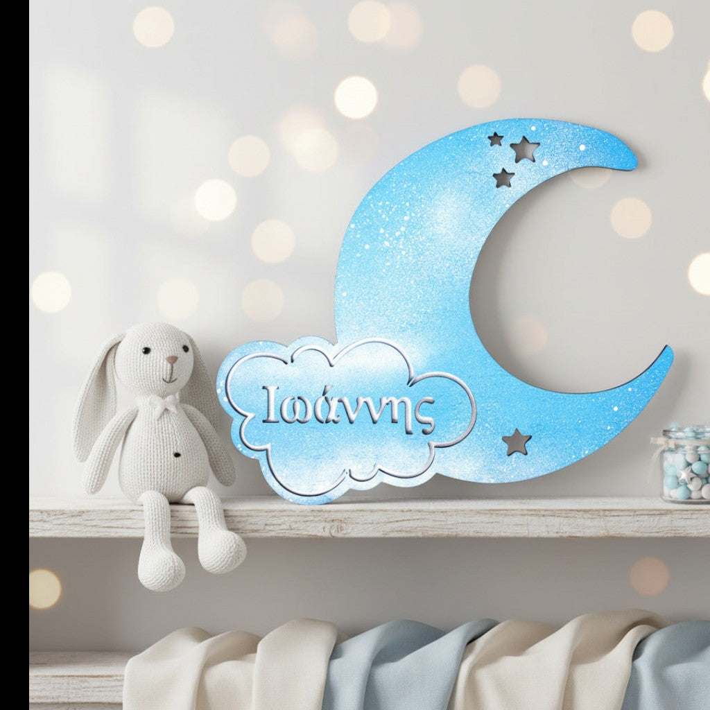 Wooderland personalized blue wooden moon wall decor with star cutouts and name display on a nursery shelf.