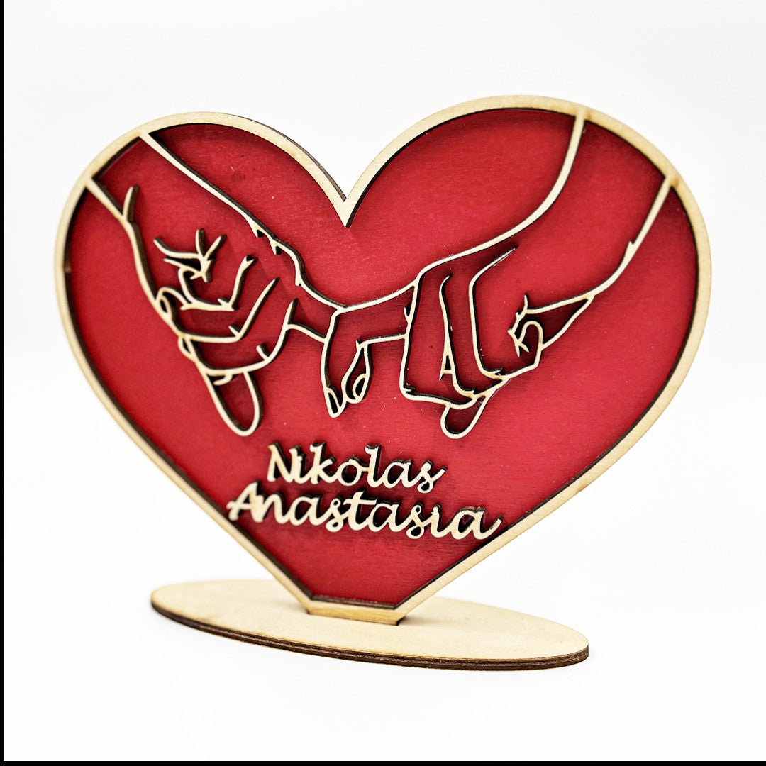 Wooderland personalized red wooden heart stand featuring carved hands and custom names on a light wood base.