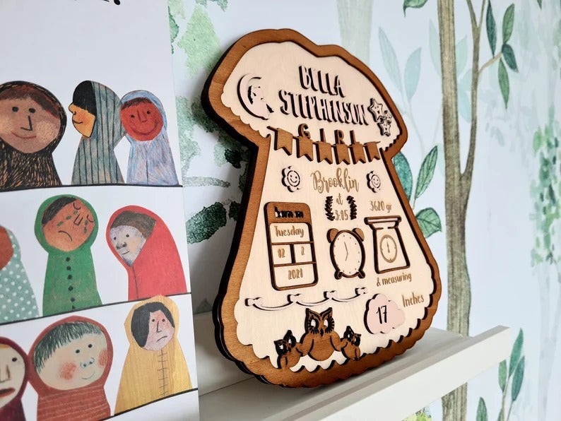 Wooderland personalized wooden baby girl birth announcement sign with engraved animal illustrations and birth details.