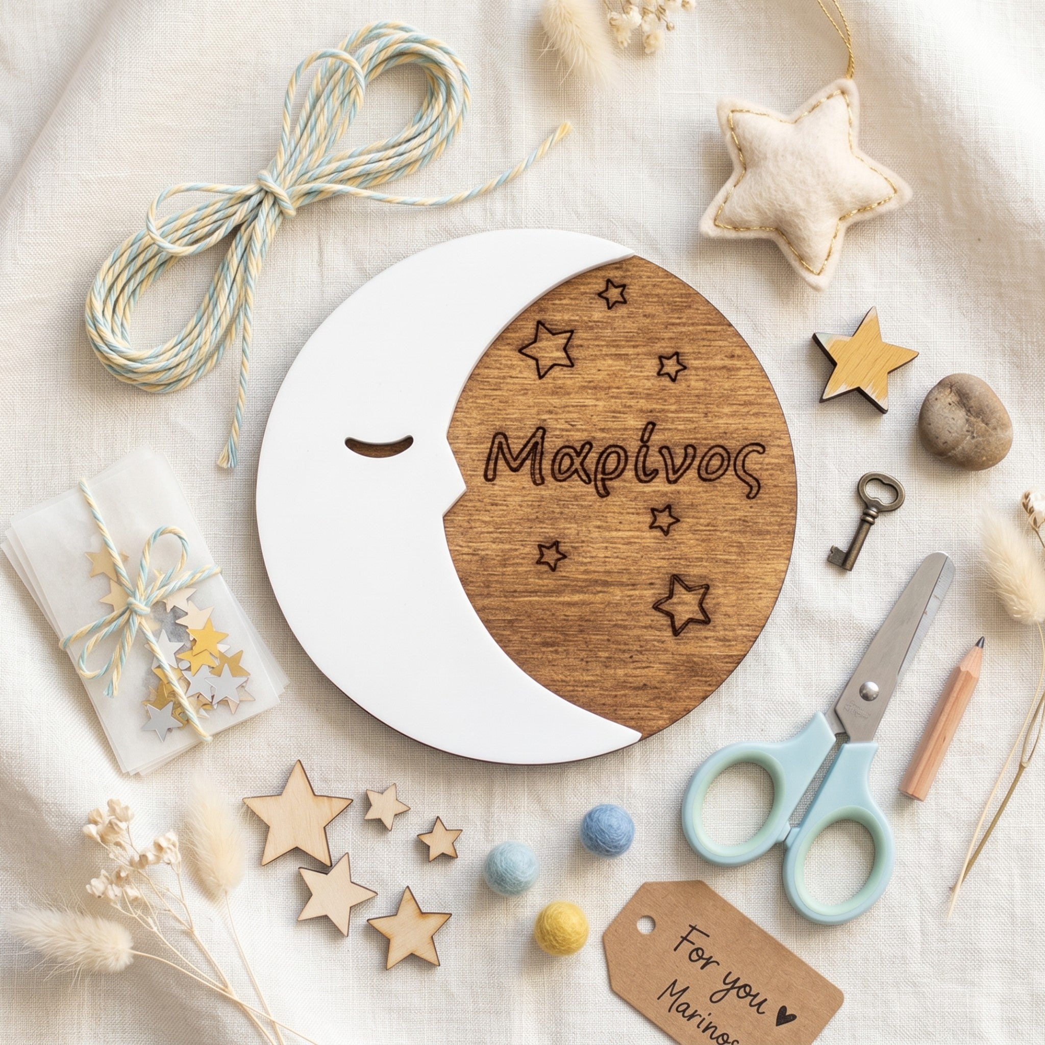 Wooderland personalized wooden half moon ornament with engraved name and stars on a white fabric background.