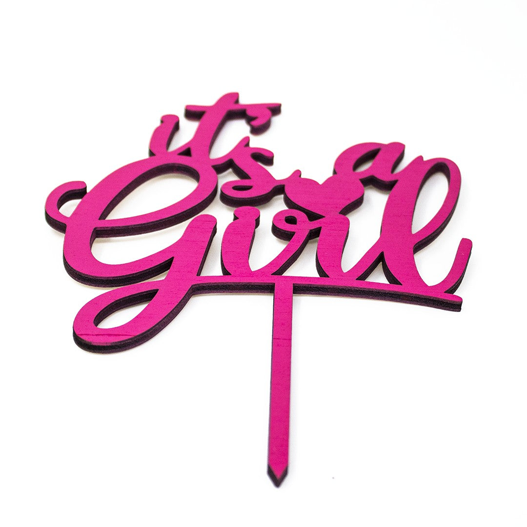 Wooderland laser-cut wooden It's a Girl cake topper in vibrant pink for baby showers and gender reveal parties.