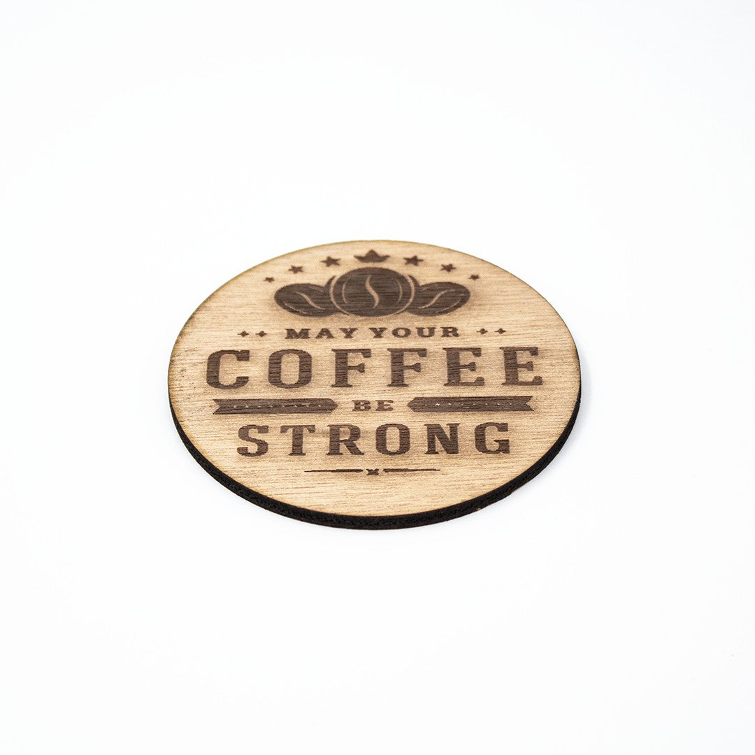 Wooderland round wooden coaster featuring laser-engraved coffee beans and the text May Your Coffee Be Strong