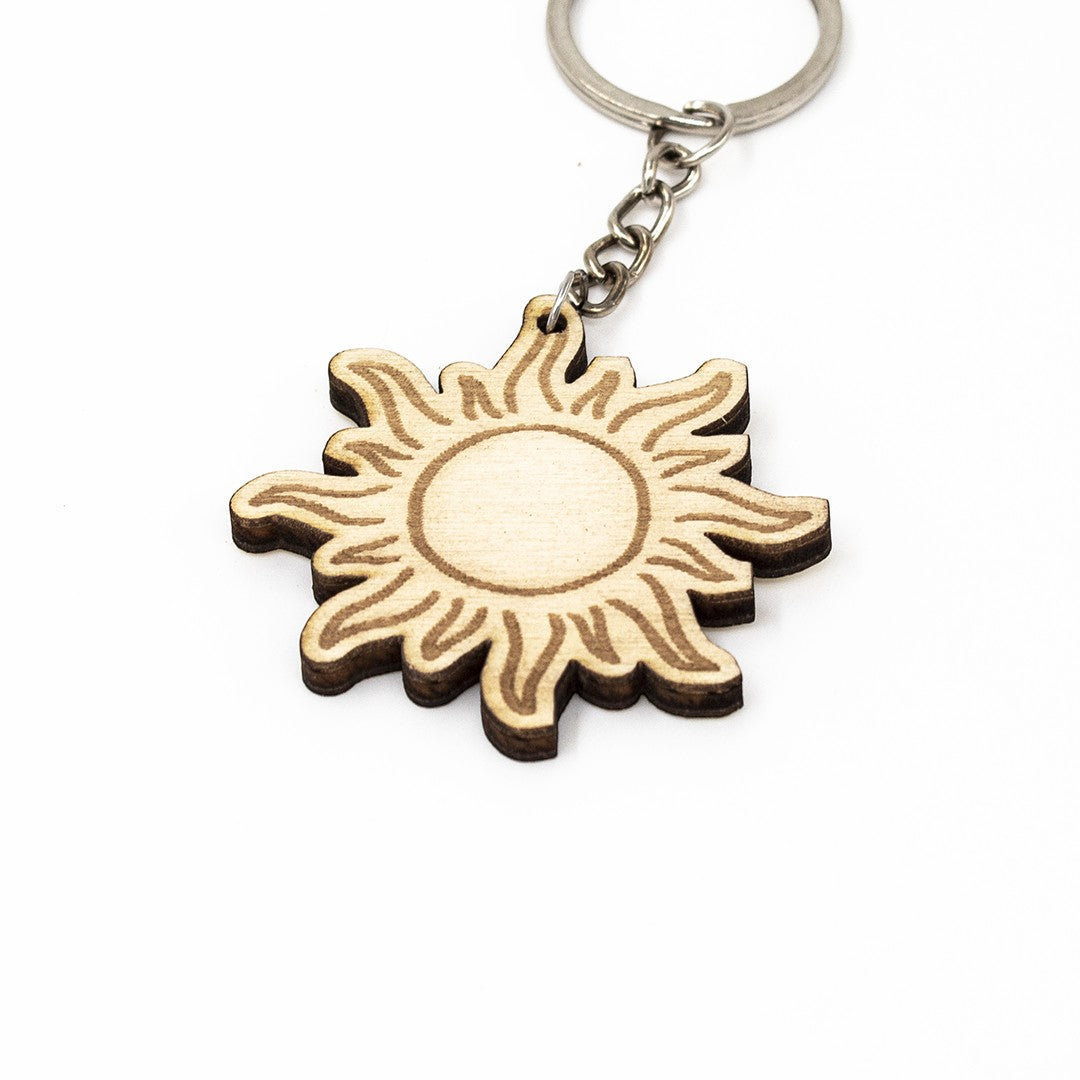 Wooderland sun-shaped wooden keyring with engraved details and a metal keychain ring on a white background.