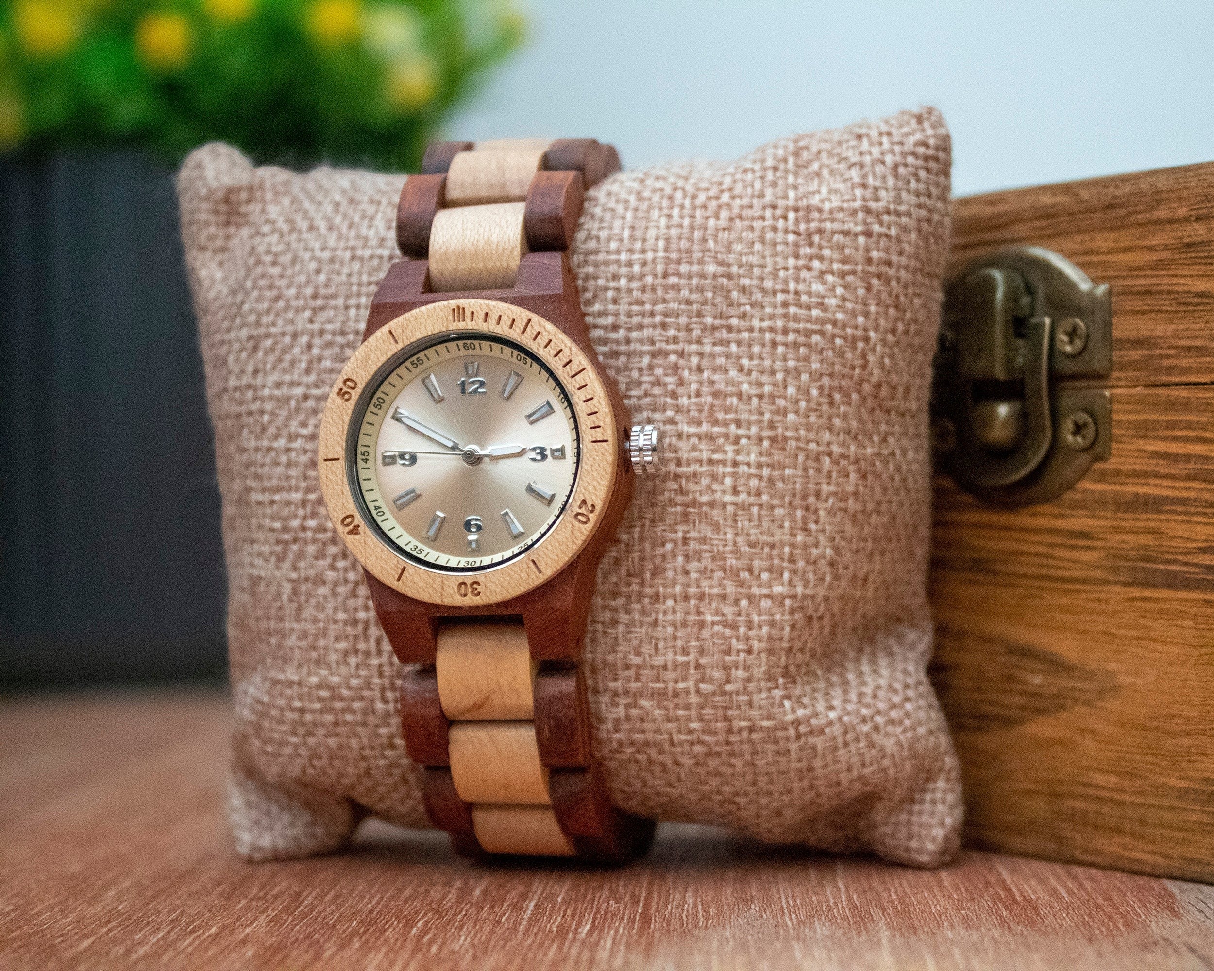 Wooderland Titania watch featuring a two-tone rosewood and light wood link strap with a silver dial on a burlap pillow