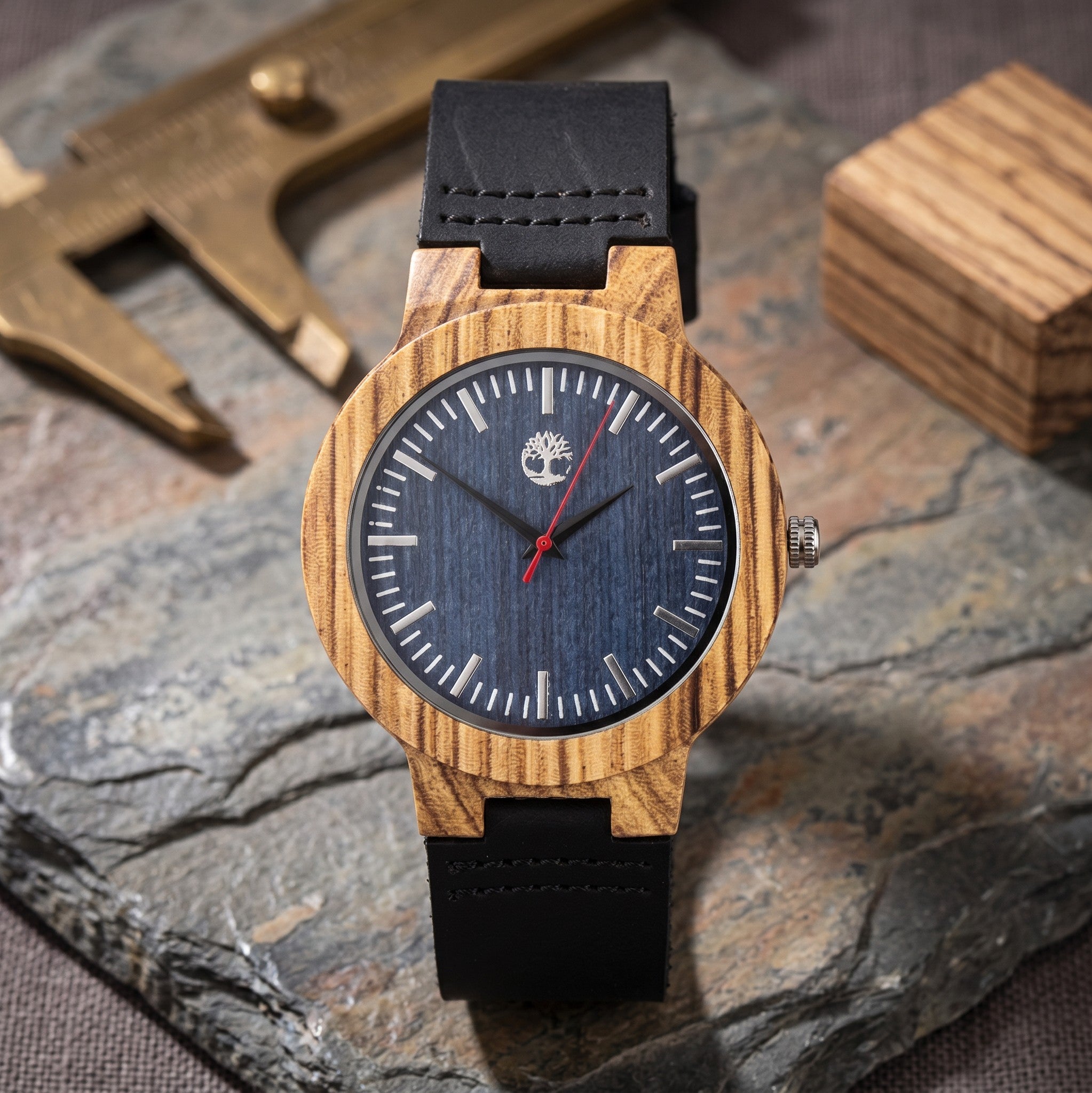 Wooderland Uranus watch featuring a natural zebra wood bezel, blue wooden dial, and black leather strap.