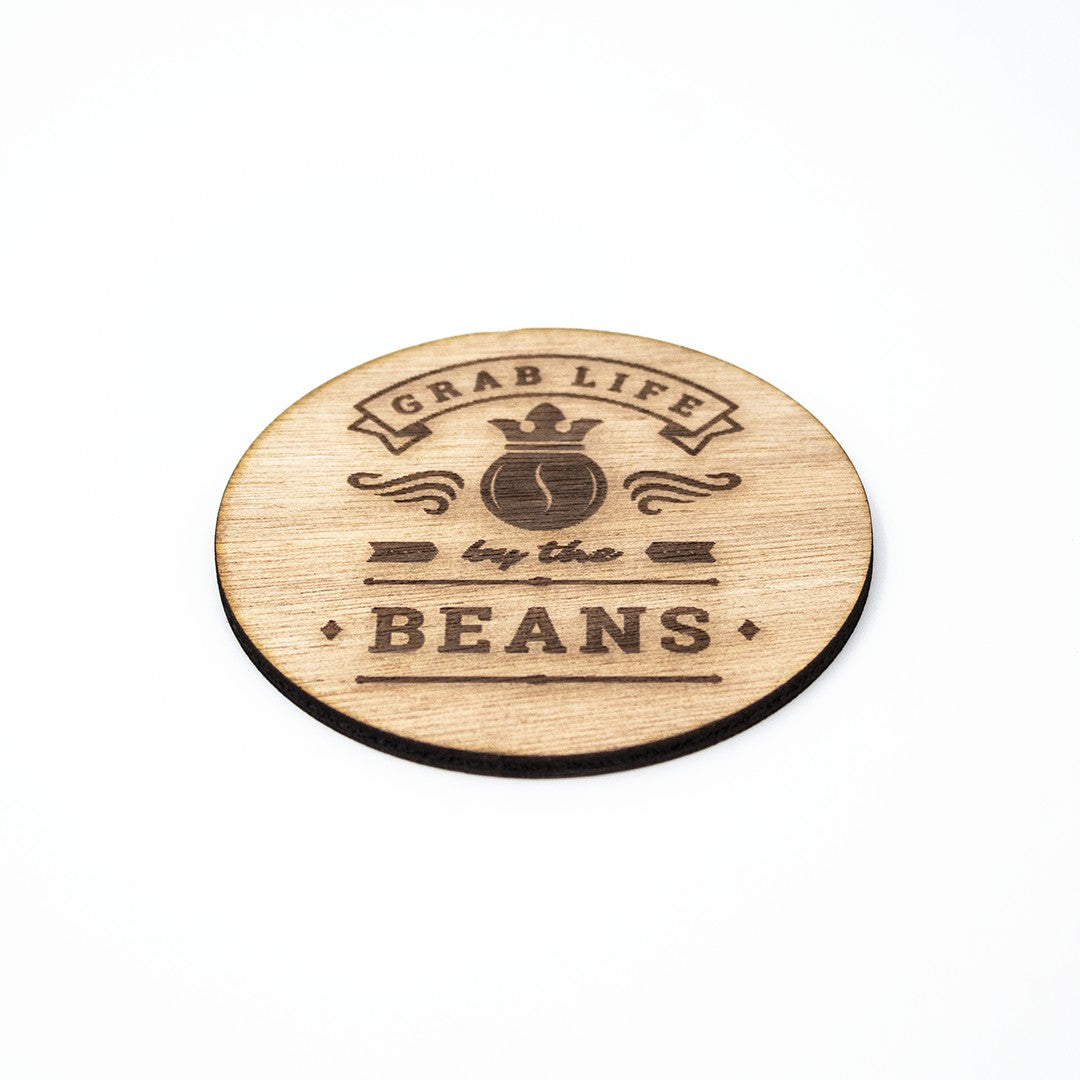 Wooderland rustic wooden coffee coaster with Grab Life by the Beans laser-engraved design on a white background