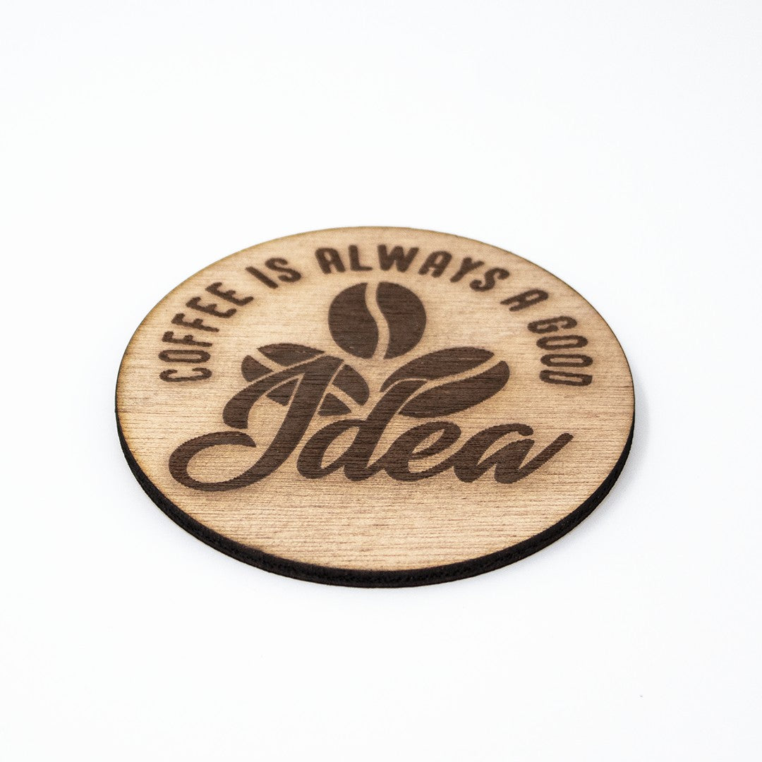 Wooderland round wooden coffee coaster with laser-engraved text Coffee Is Always A Good Idea and coffee bean icon