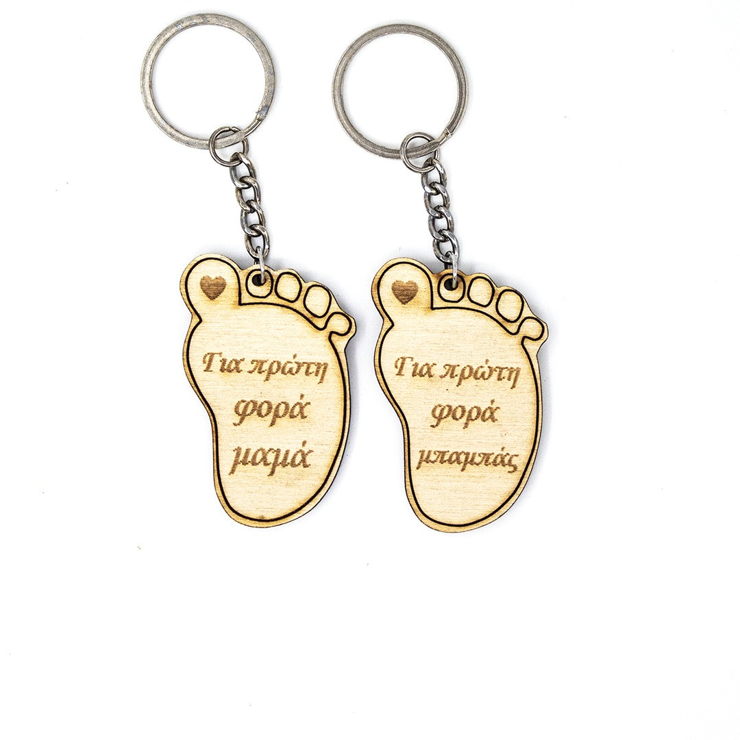 Wooderland wooden foot-shaped keyrings for new parents with engraved Greek text and a small heart detail.