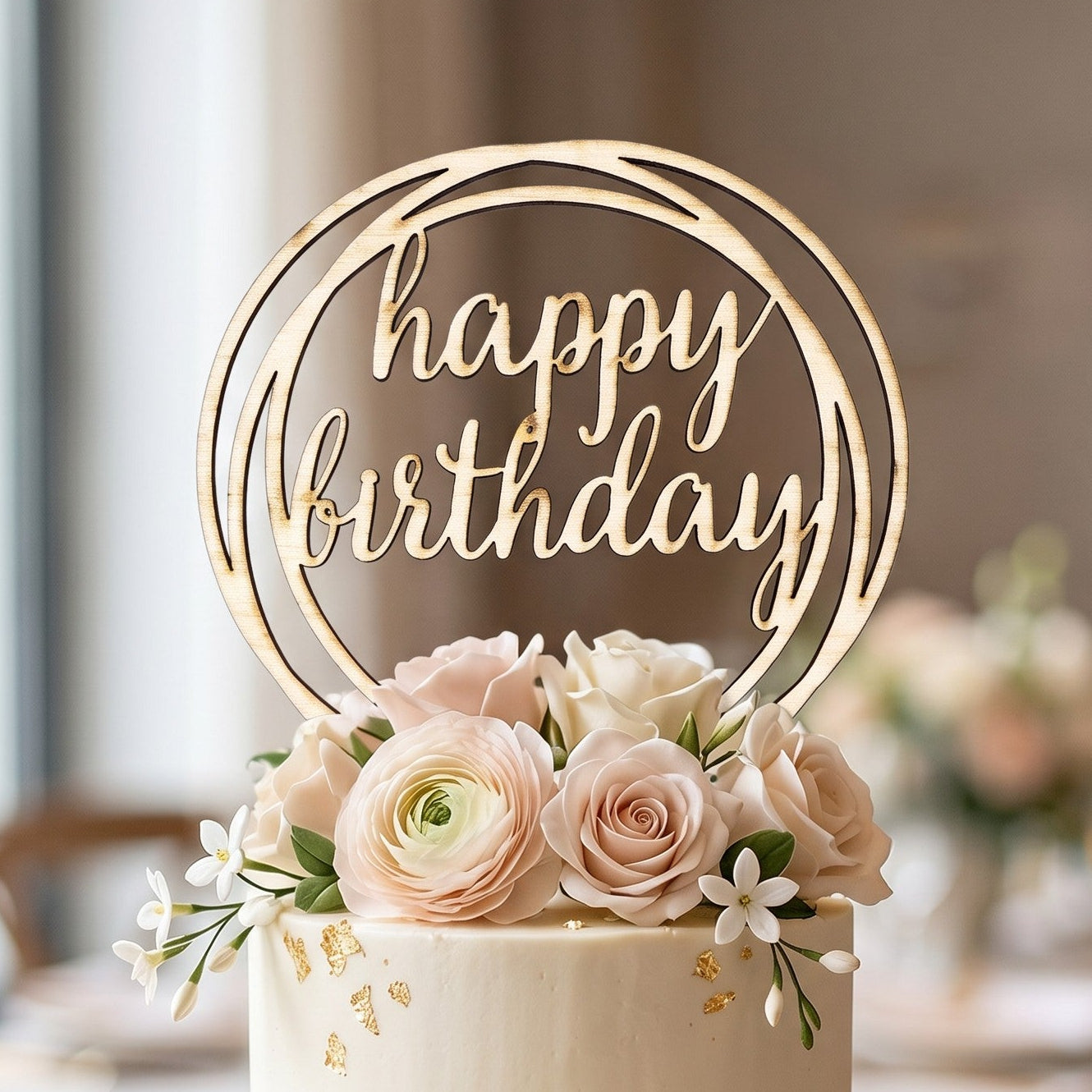 Wooderland wooden Happy Birthday cake topper in a circular frame, displayed on a two-tier cream cake with floral decor.
