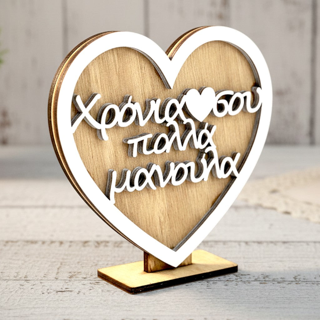 Wooderland heart-shaped wooden desk ornament with white Greek text for Mother's Day on a rustic white table.