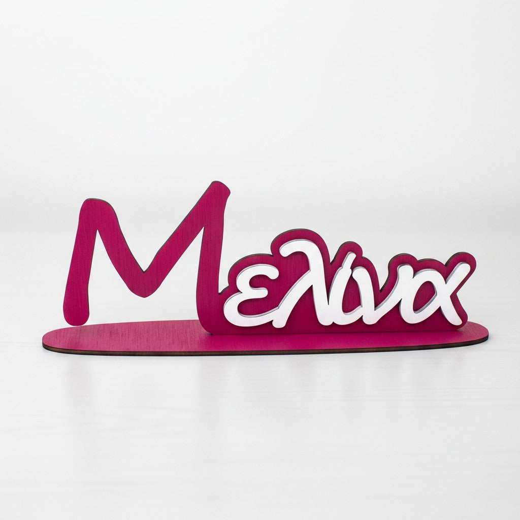 Wooderland custom two-tone wooden name stand in magenta and white for a child's room or desk decor.