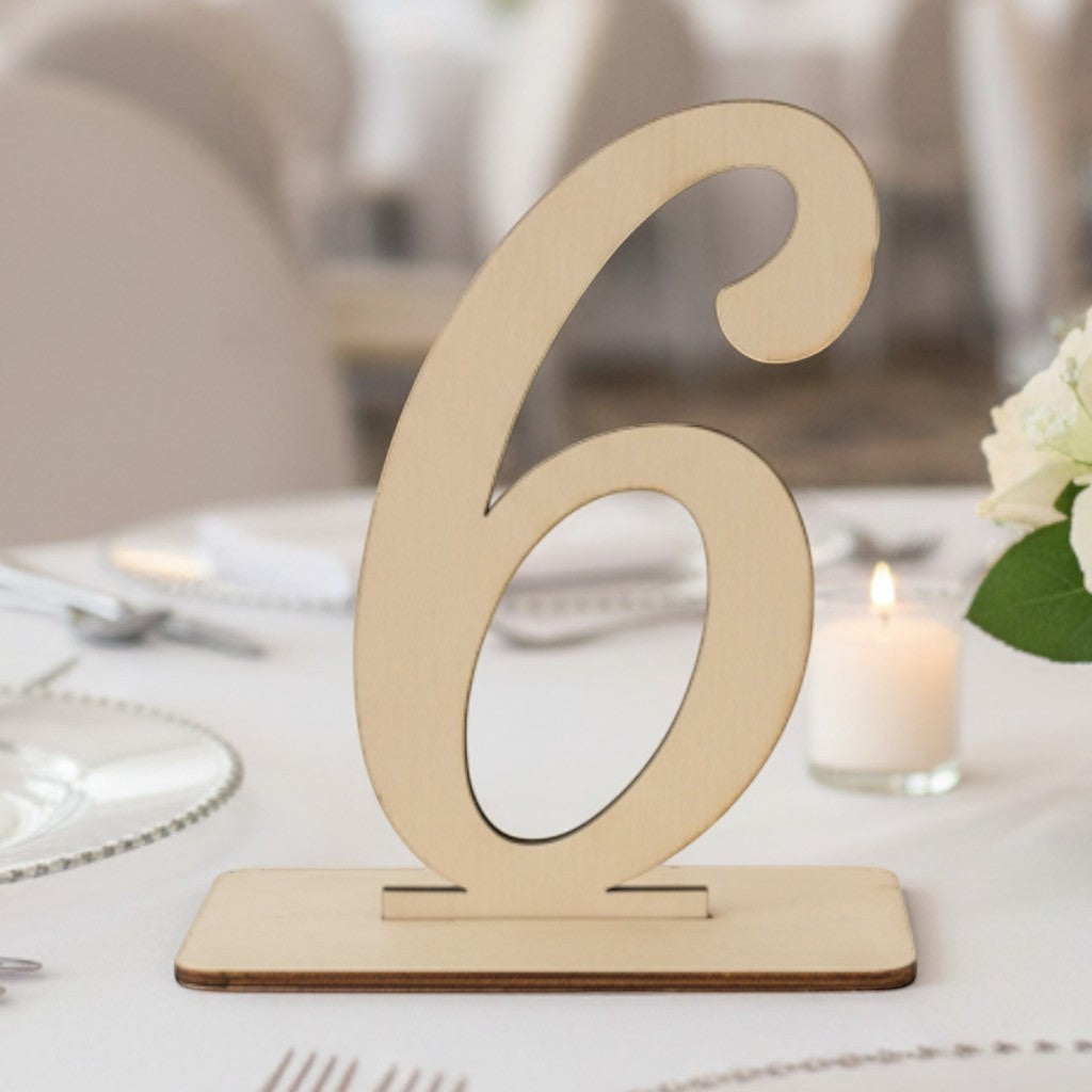 Wooderland wooden table number six on a wedding reception table with white roses and elegant place settings.
