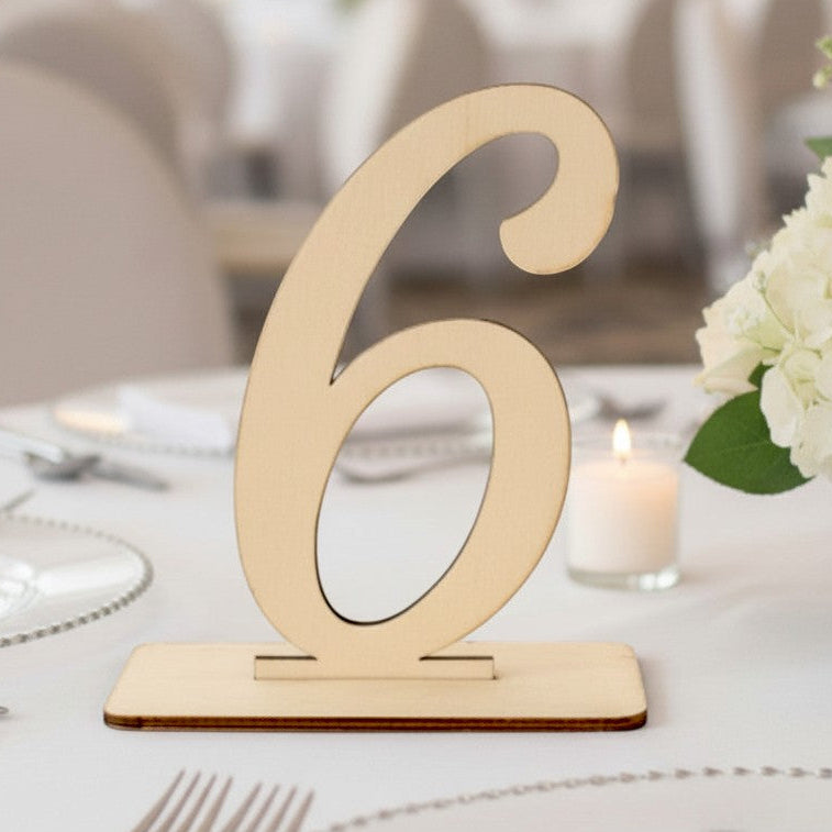 Wooderland wooden table number six stand with a natural finish on a white wedding reception table setting.