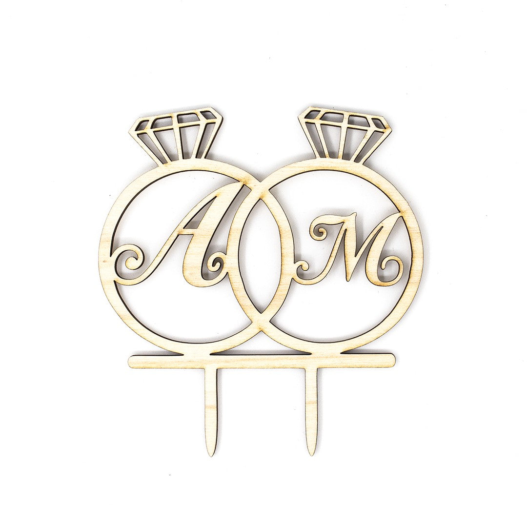 Wooderland custom wooden wedding cake topper featuring two interlinked rings engraved with initials A and M.