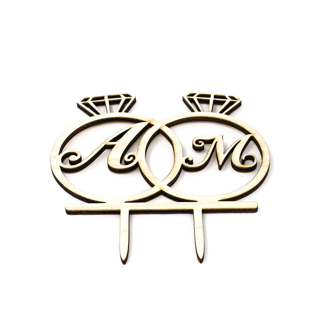 Wooderland custom wooden wedding cake topper featuring two interlinked rings with engraved initials A and M