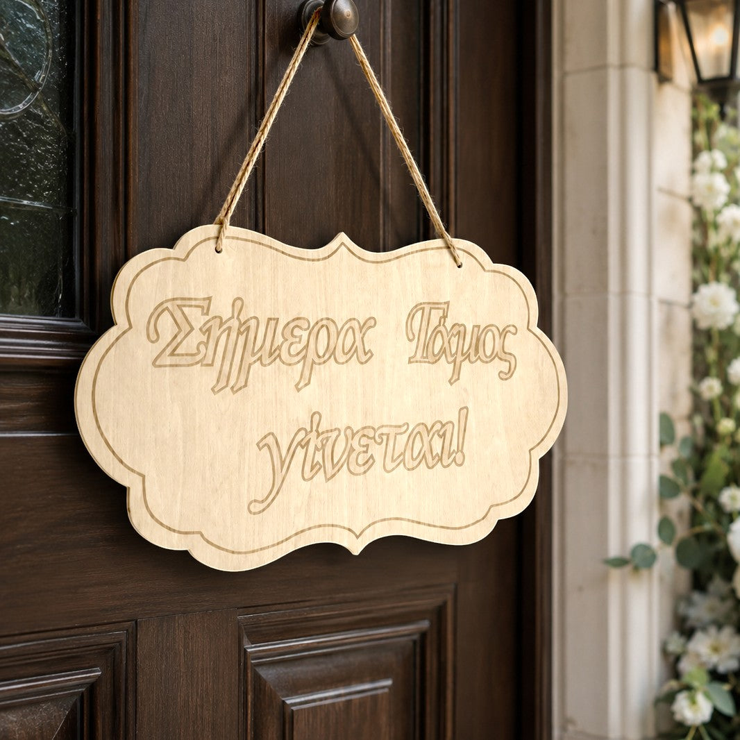 Wooderland laser-cut wooden wedding welcome sign with Greek text hanging on a dark wooden door.