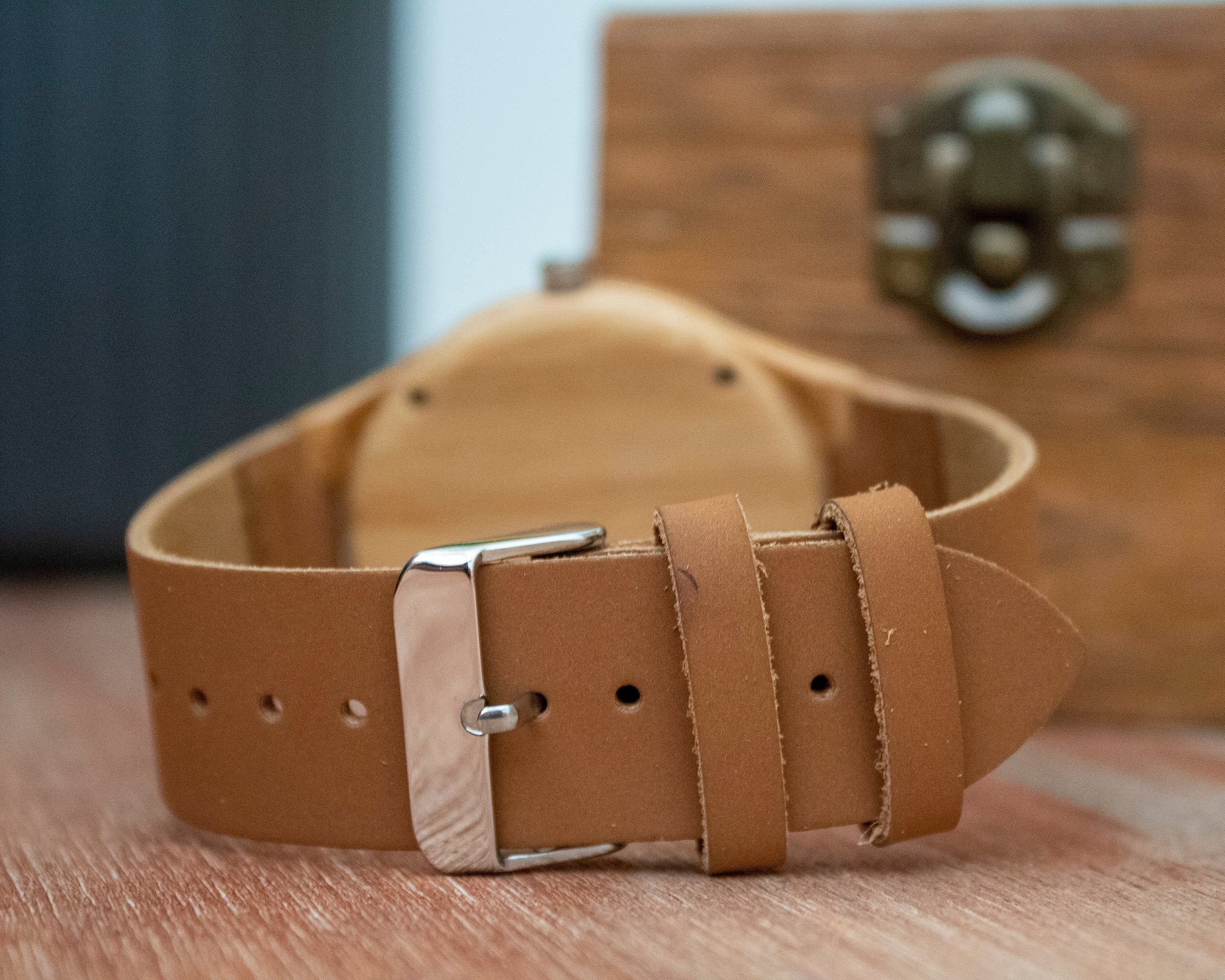 Wooderland Zeus watch featuring a tan leather strap with a silver buckle, shown from the back with a wooden gift box.
